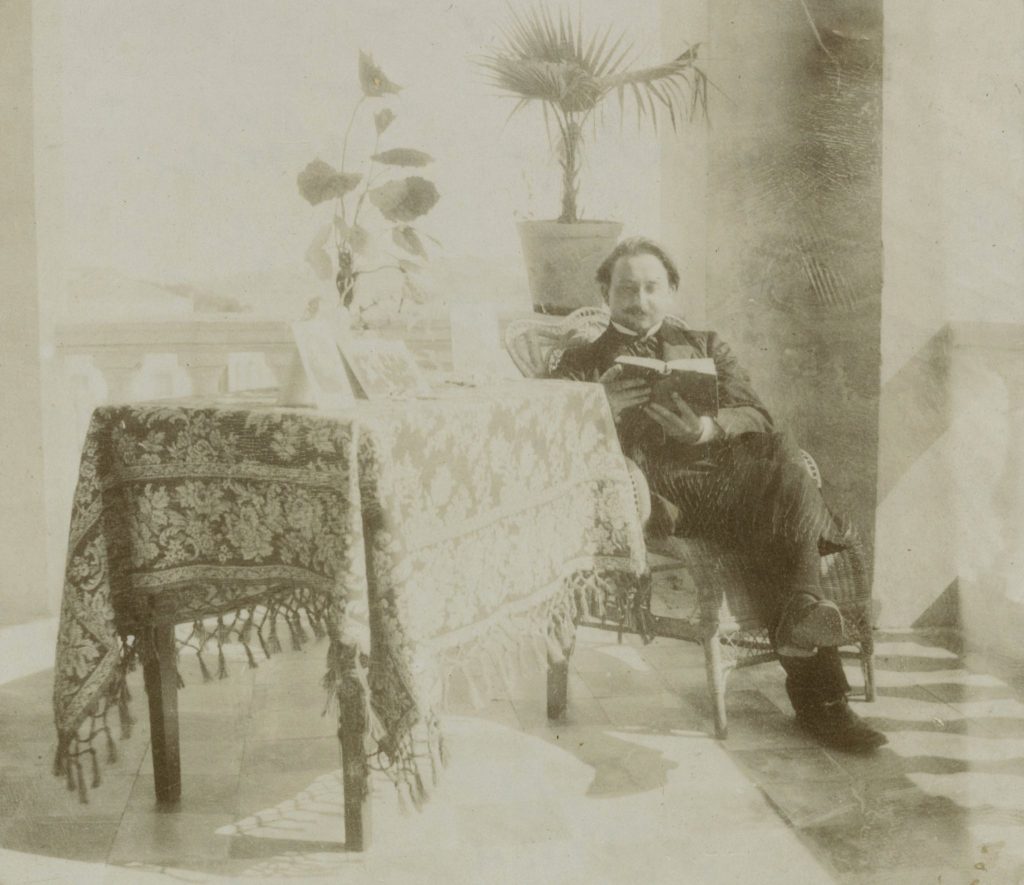 Mężczyzna czytający książkę w jasnym pomieszczeniu.