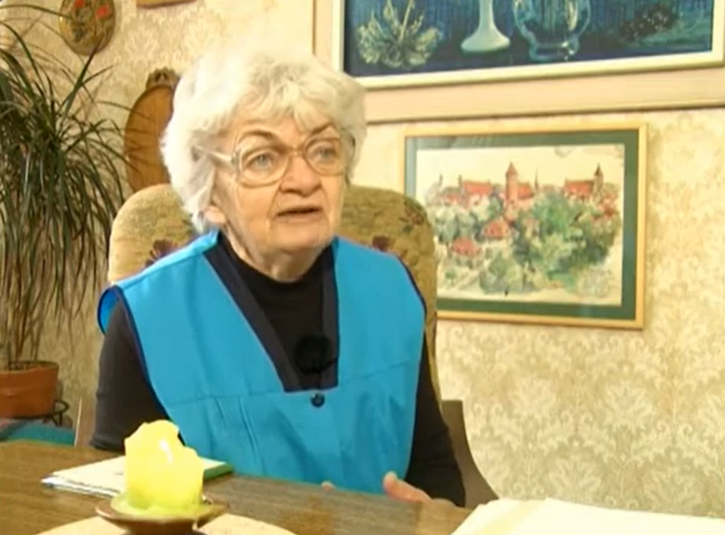 Starsza kobieta rozmawia w pokoju.