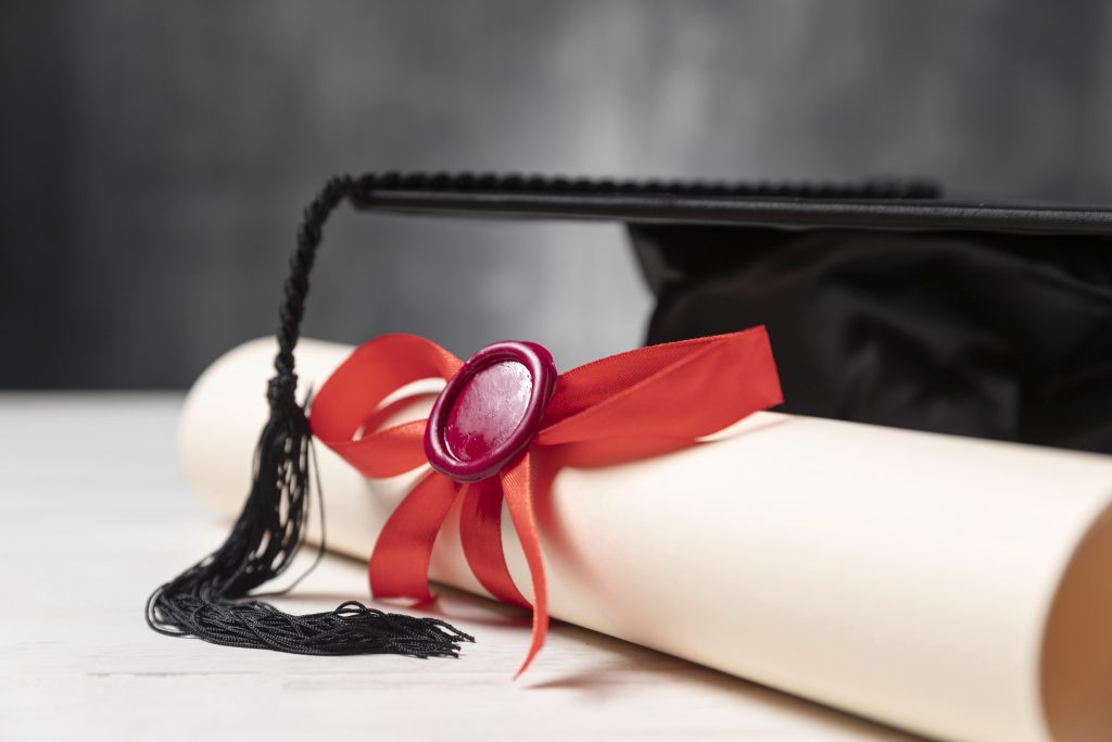 Czapka absolwenta i dyplom z wstążką