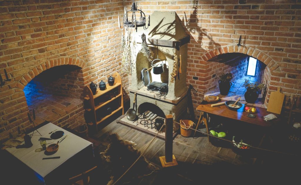 Tradycyjna kuchnia z kominkiem i drewnianymi akcentami.