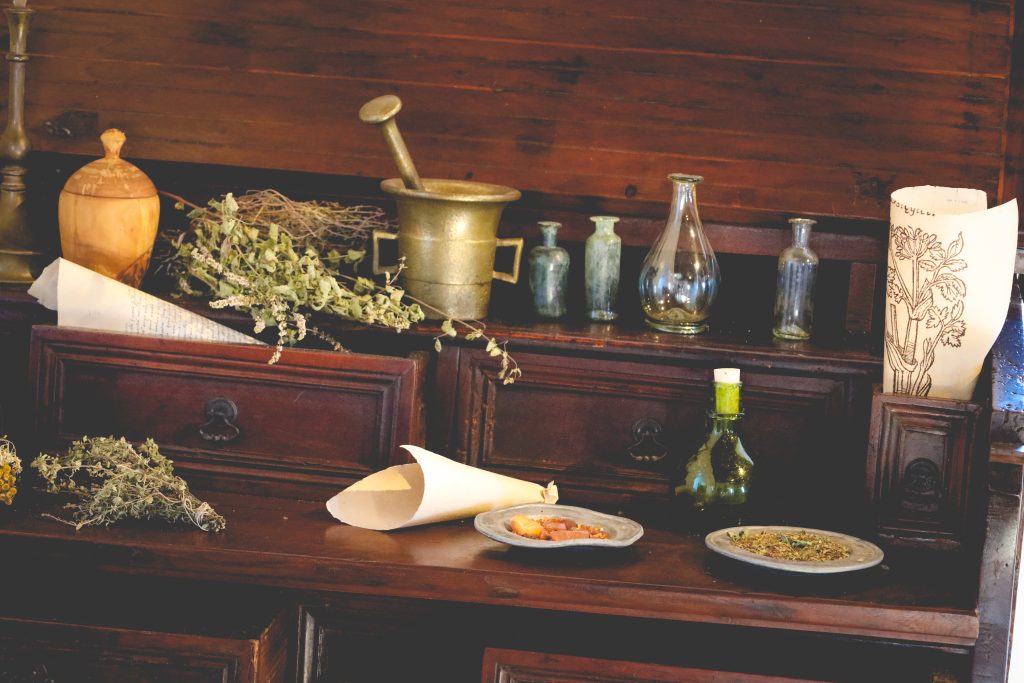 Stare przedmioty i zioła na drewnianym stole.