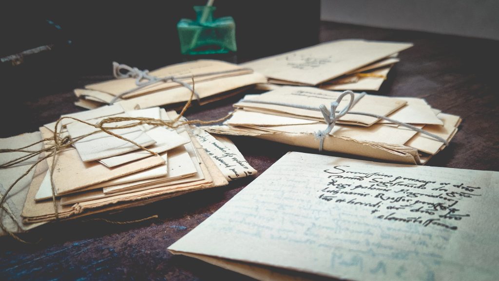 Stare listy związane sznurkiem na drewnianym stole.