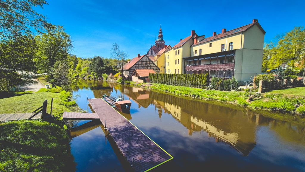 Widok na rzekę z przystanią i budynkami w tle.