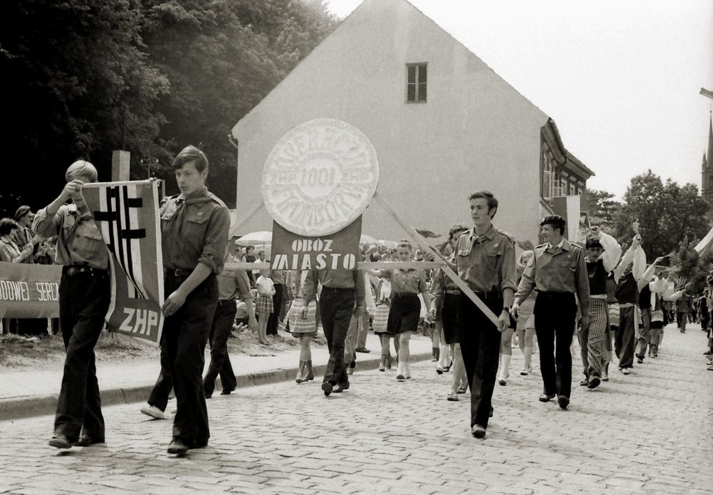 Młodzież niosąca flagi podczas parady