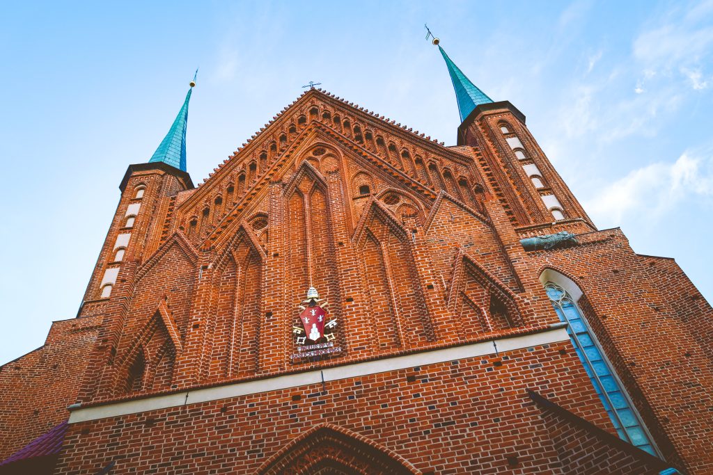 Widok na ceglany kościół z wieżami.