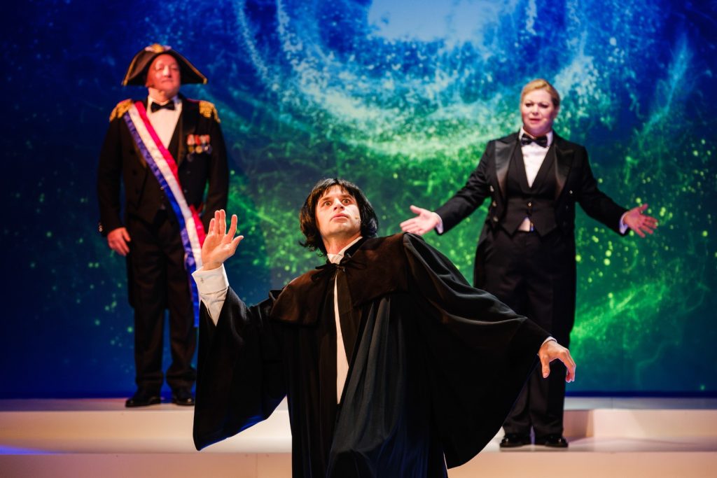 Trzech aktorów na scenie w kostiumach.