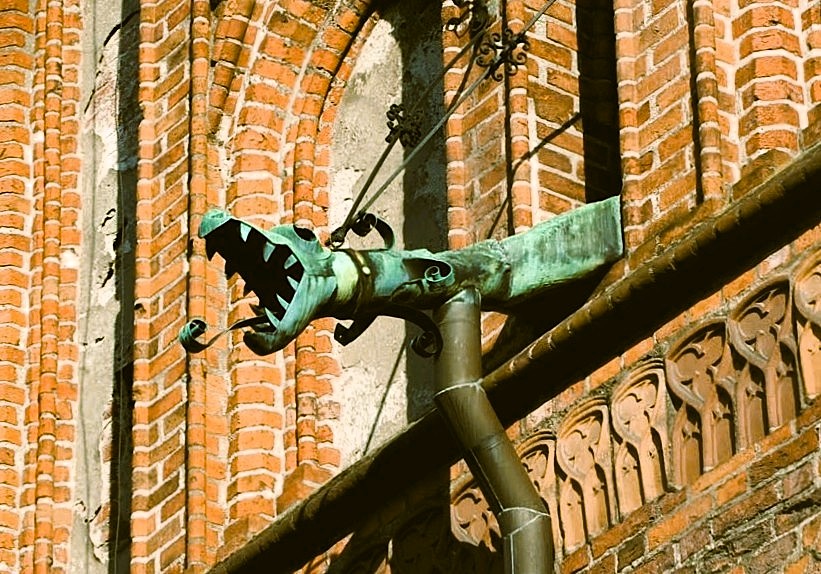 Miedziana rura w kształcie smoka na budynku.