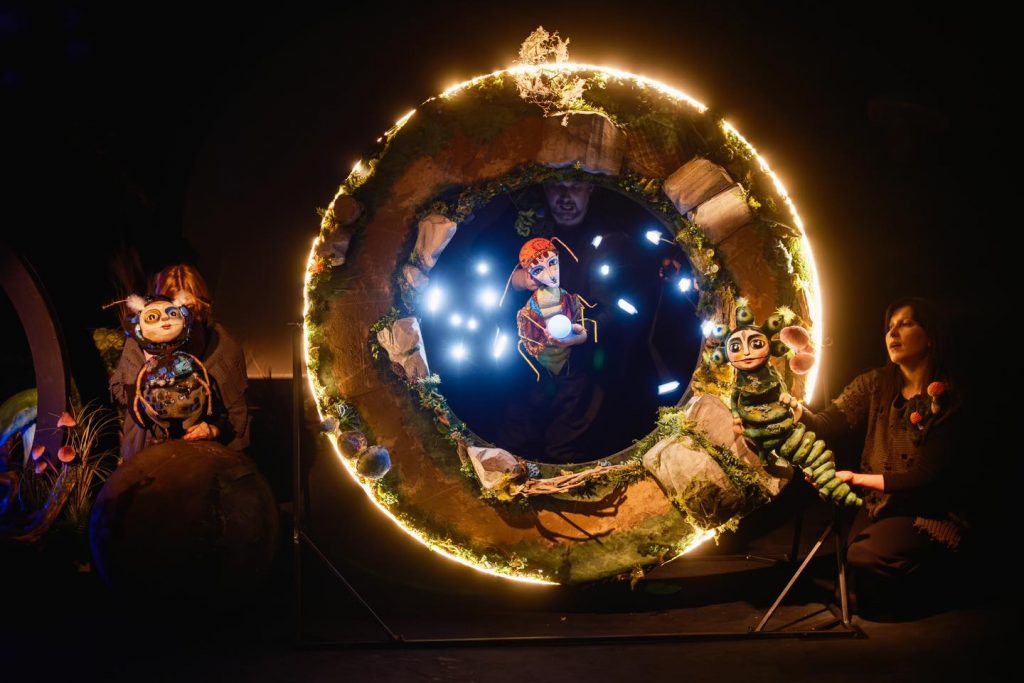 Scena z marionetkami w magicznym otoczeniu.